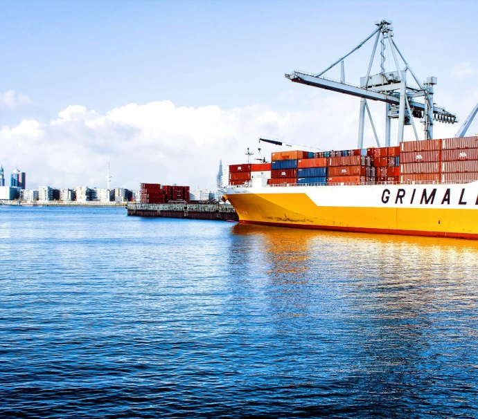 white and orange cargo ship with metal lifting equipment